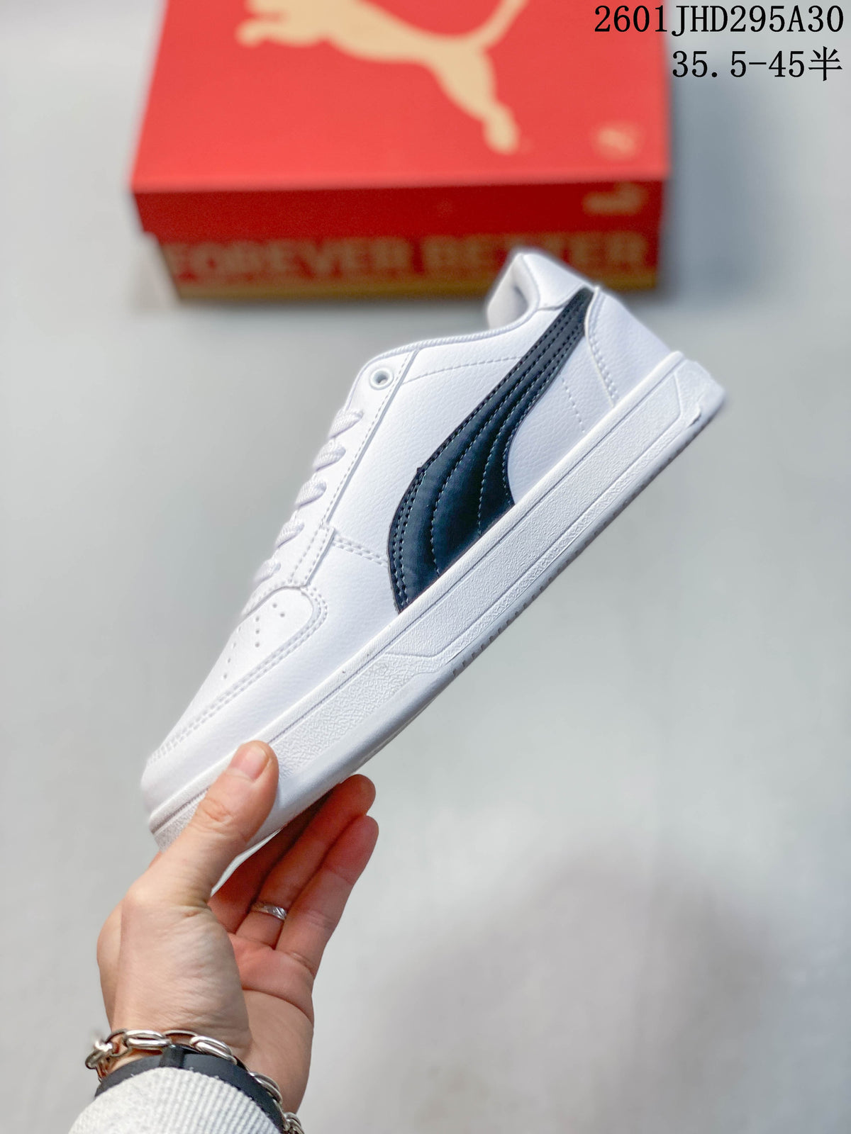 Side view of a white Puma Caven 2.0 sneaker with a dark stripe and gold-tone detail