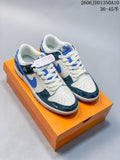 Pair of white, dark teal and blue Nike SB Dunk Low sneakers on an orange box