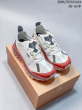 Pair of white Norda 001 sneakers with dark accents and rose-colored soles, shown on a box.
