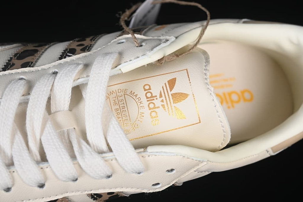 Close-up of the tongue with gold adidas branding and white laces
