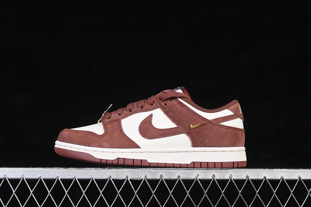 Side view of a brown and white Nike SB Dunk Low with a gold-tone mini Swoosh detail