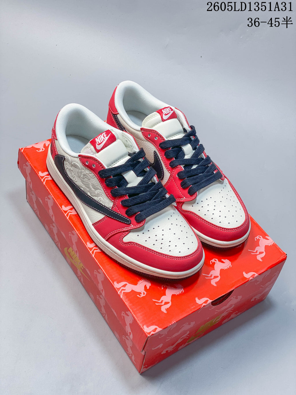 Off-white and red Nike Dunk Low sneakers with dark navy laces and embroidered side panels