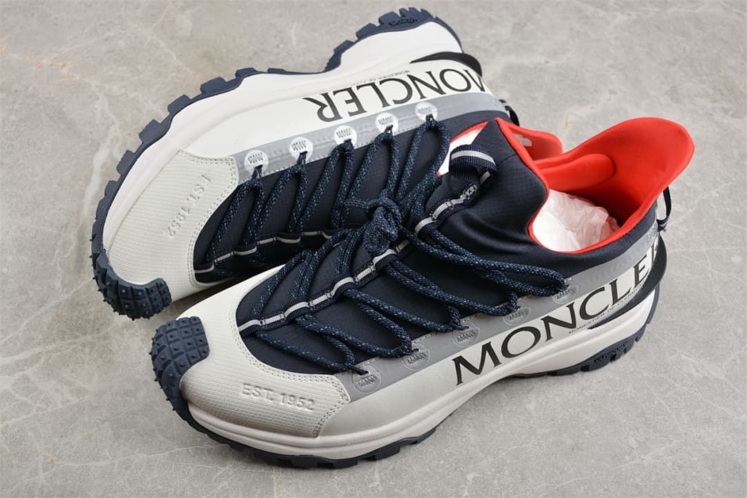 Pair of white and navy Trailgrip Lite2 sneakers with red collar accents.