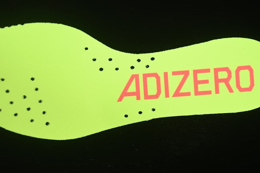 Close-up of the neon yellow-green insole with Adizero branding.