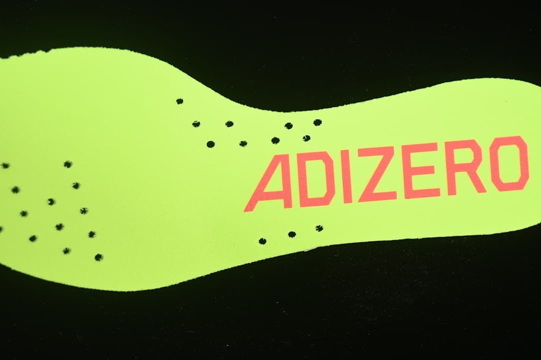 Close-up of the neon yellow-green insole with Adizero branding.
