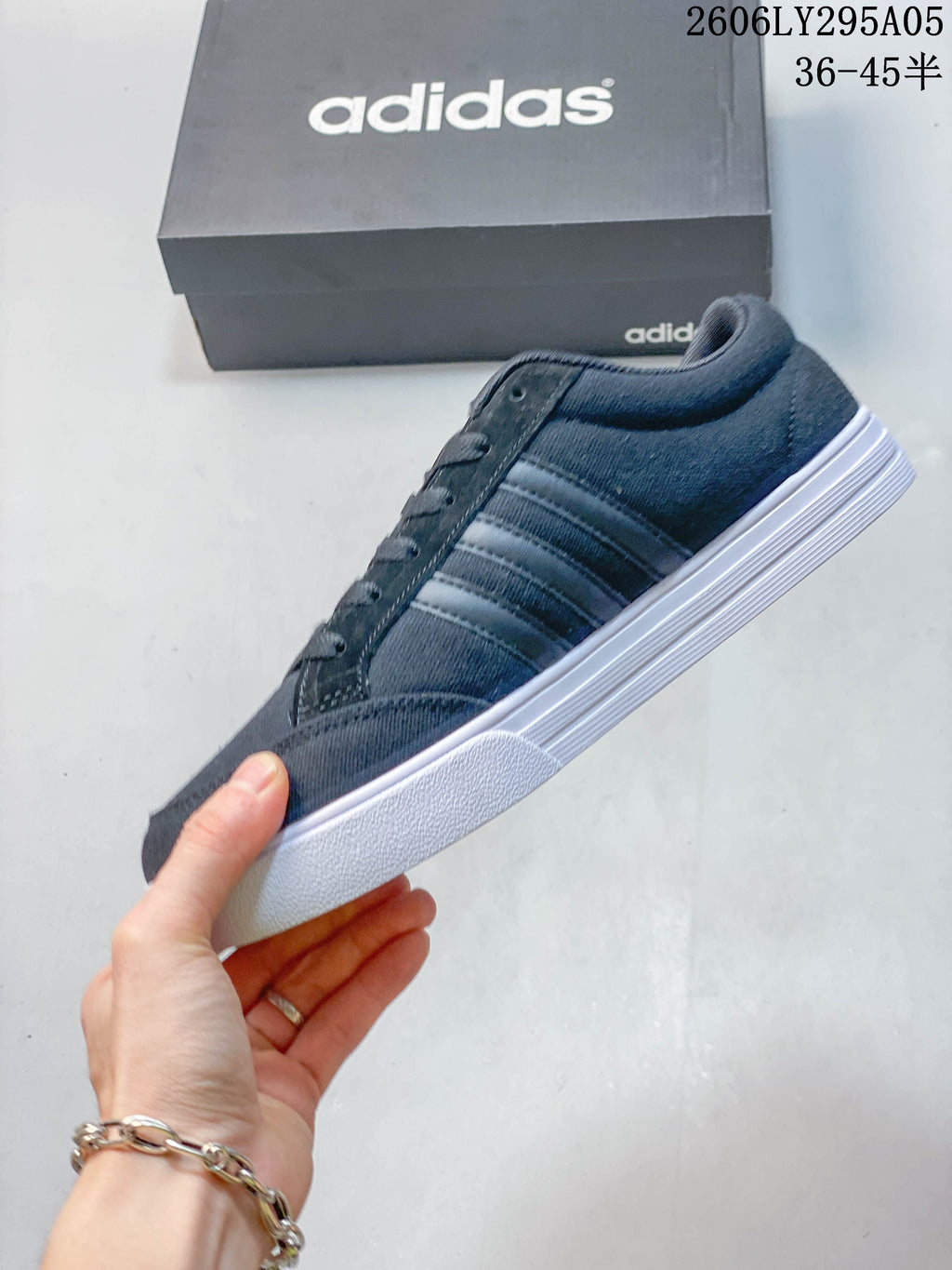 Side profile of the dark gray sneaker showing three side stripes and white sole