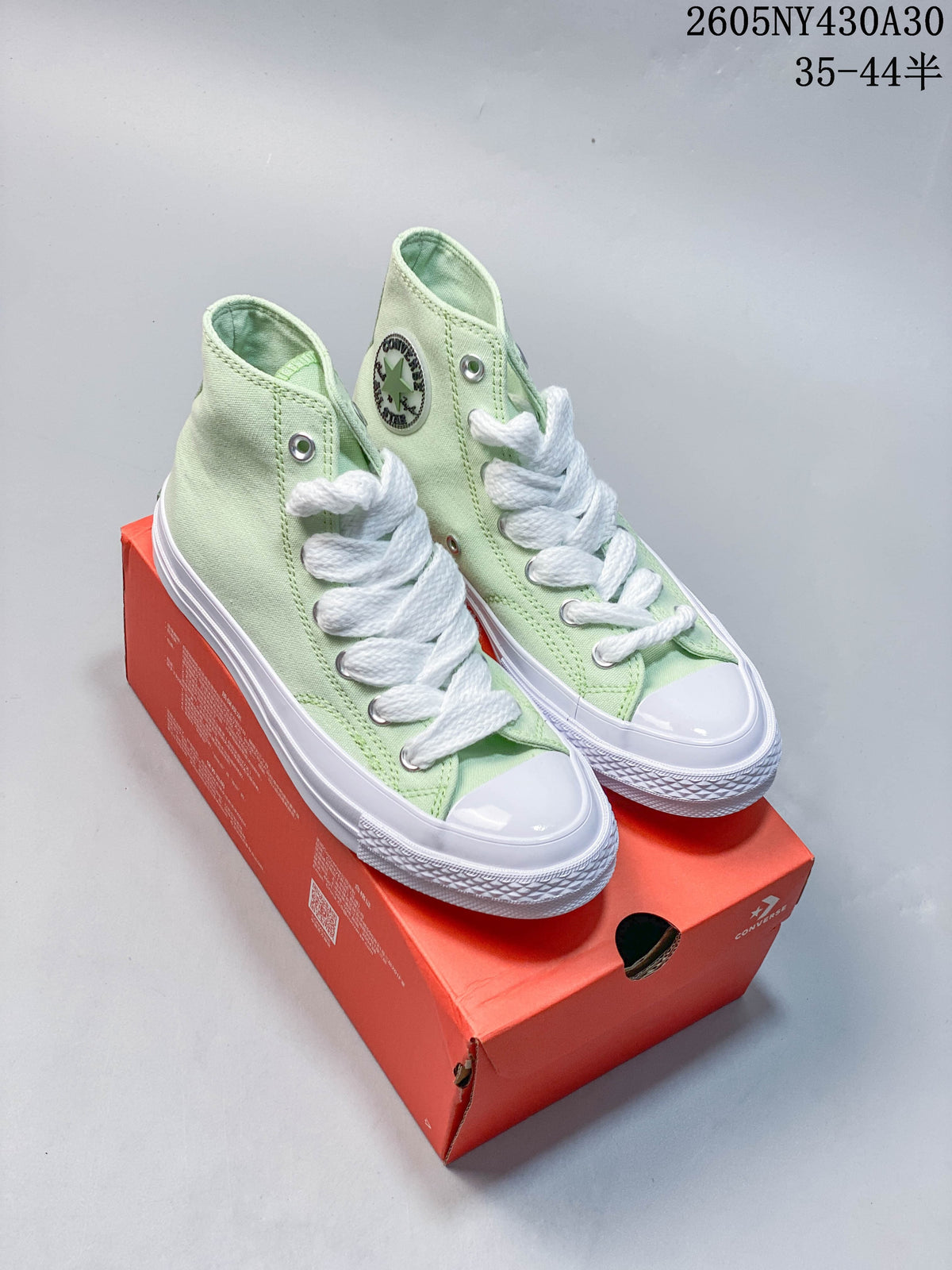 Pair of pale mint green Converse high-top sneakers with white laces and white soles