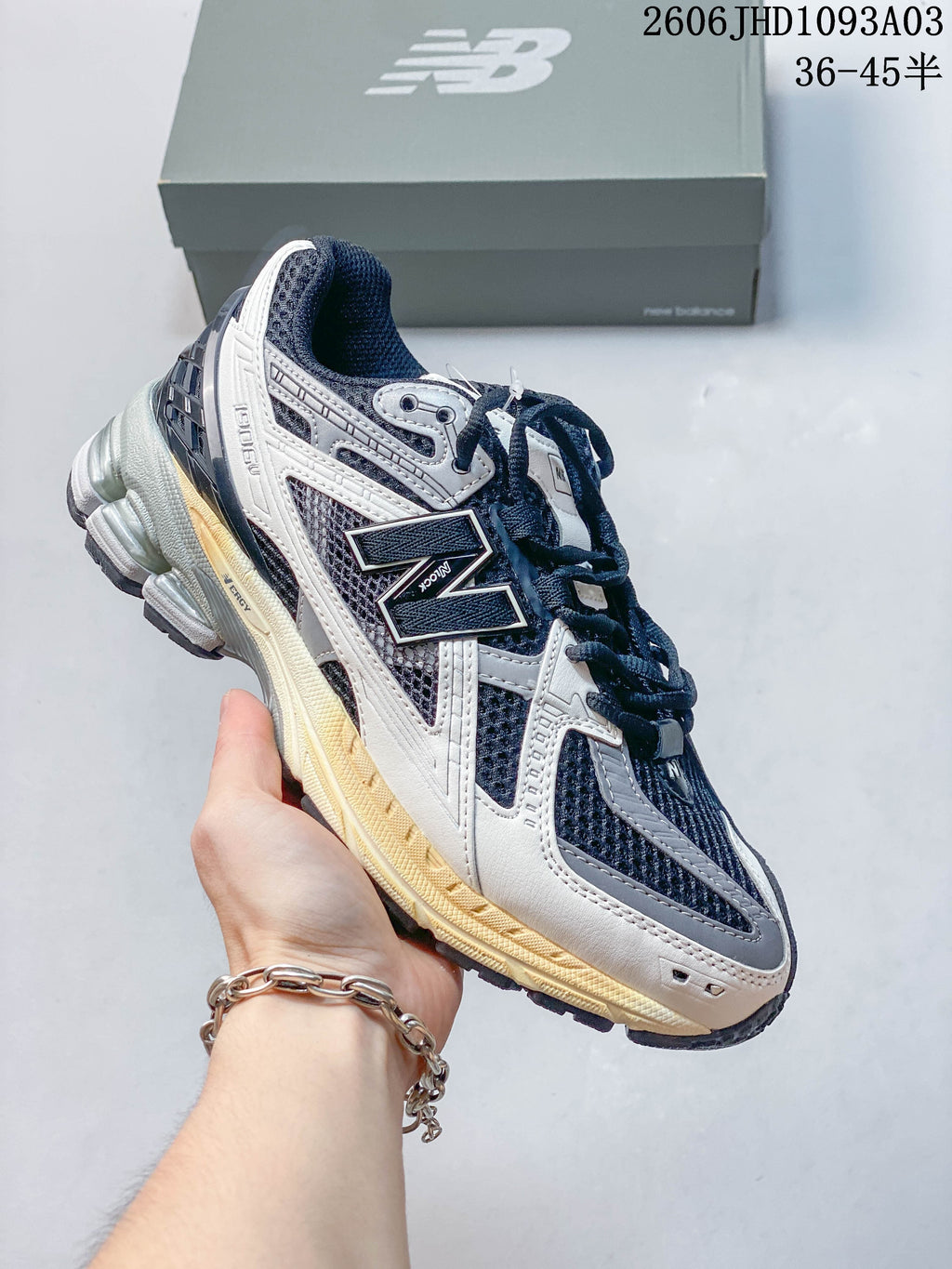 Navy and gray New Balance 1906U sneaker with a light-colored sole