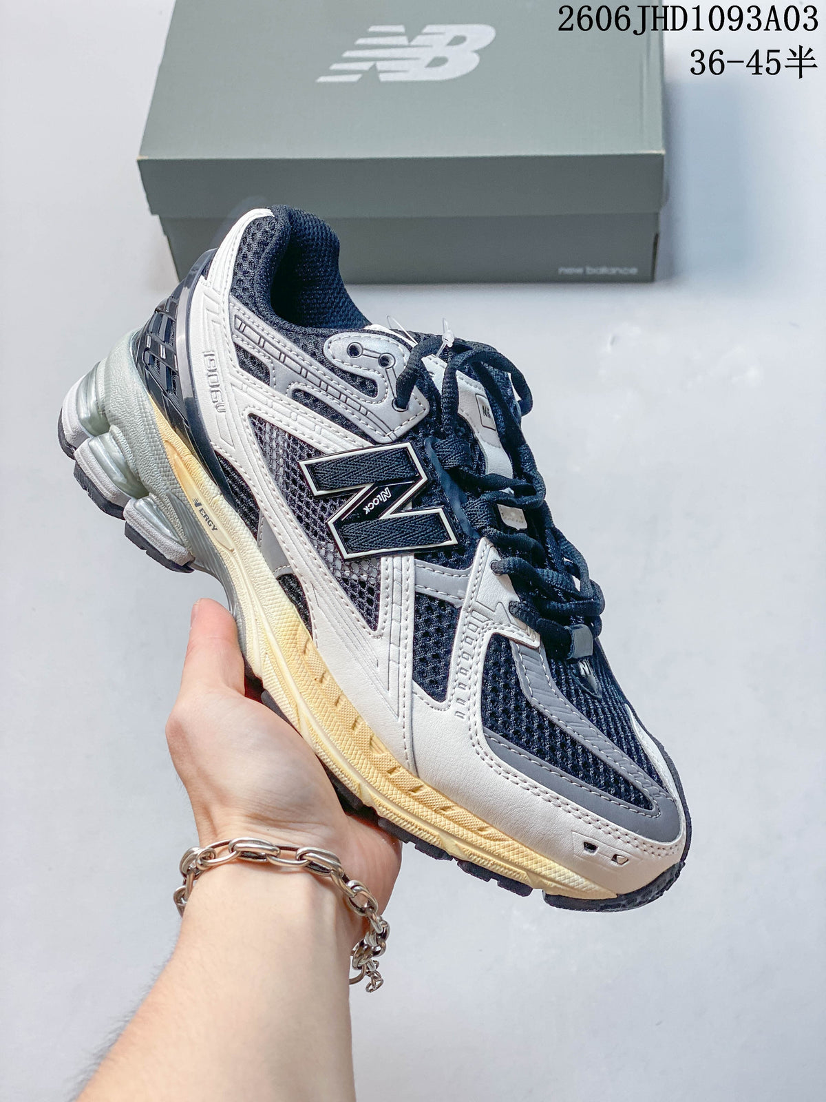 Navy and gray New Balance 1906U sneaker with a light-colored sole