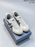 Pair of ivory-colored Onitsuka Tiger Mexico 66 sneakers with dark navy stripes, shown on a shoe box.