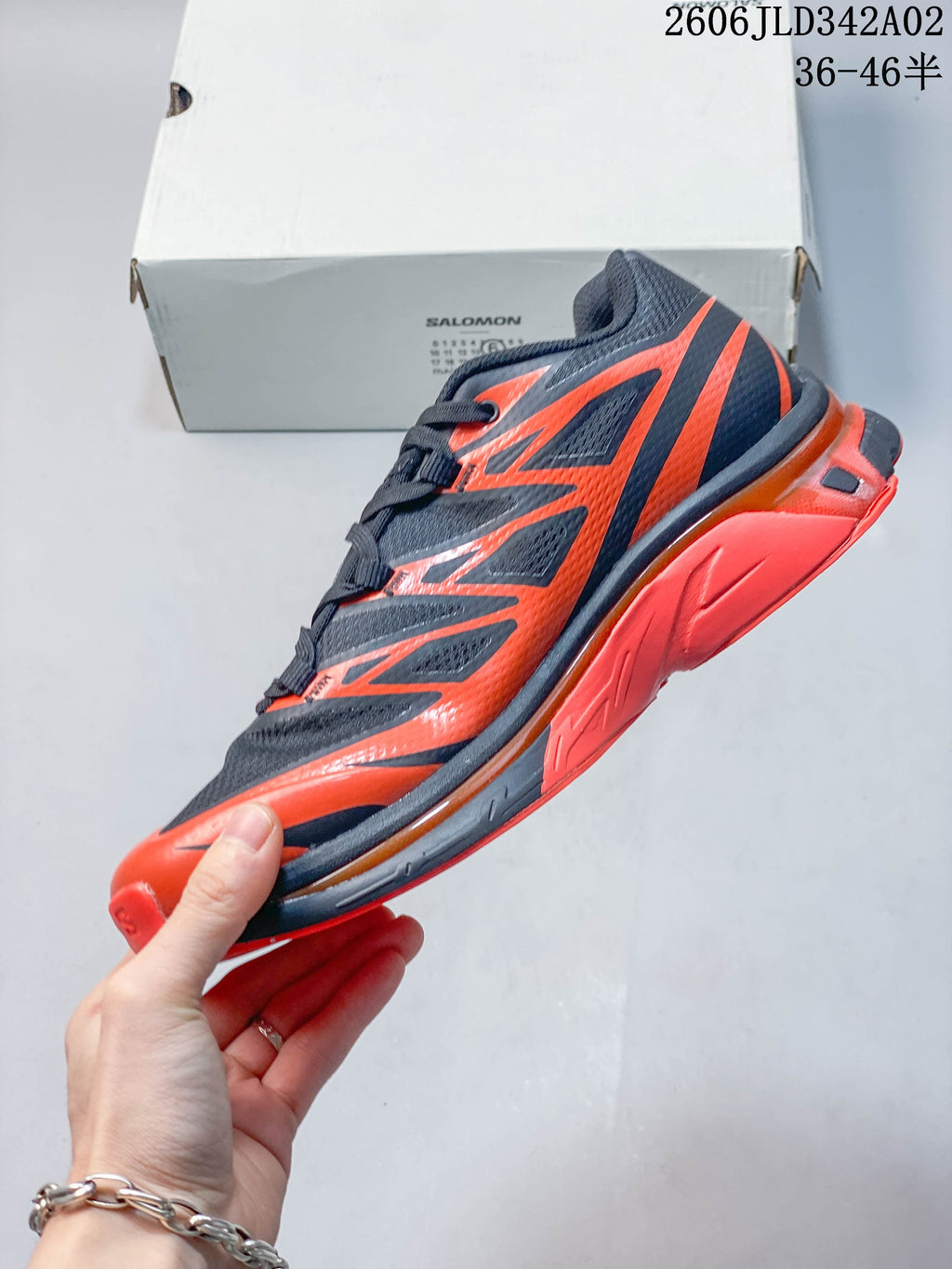 Side profile showing the navy and orange upper and sole.