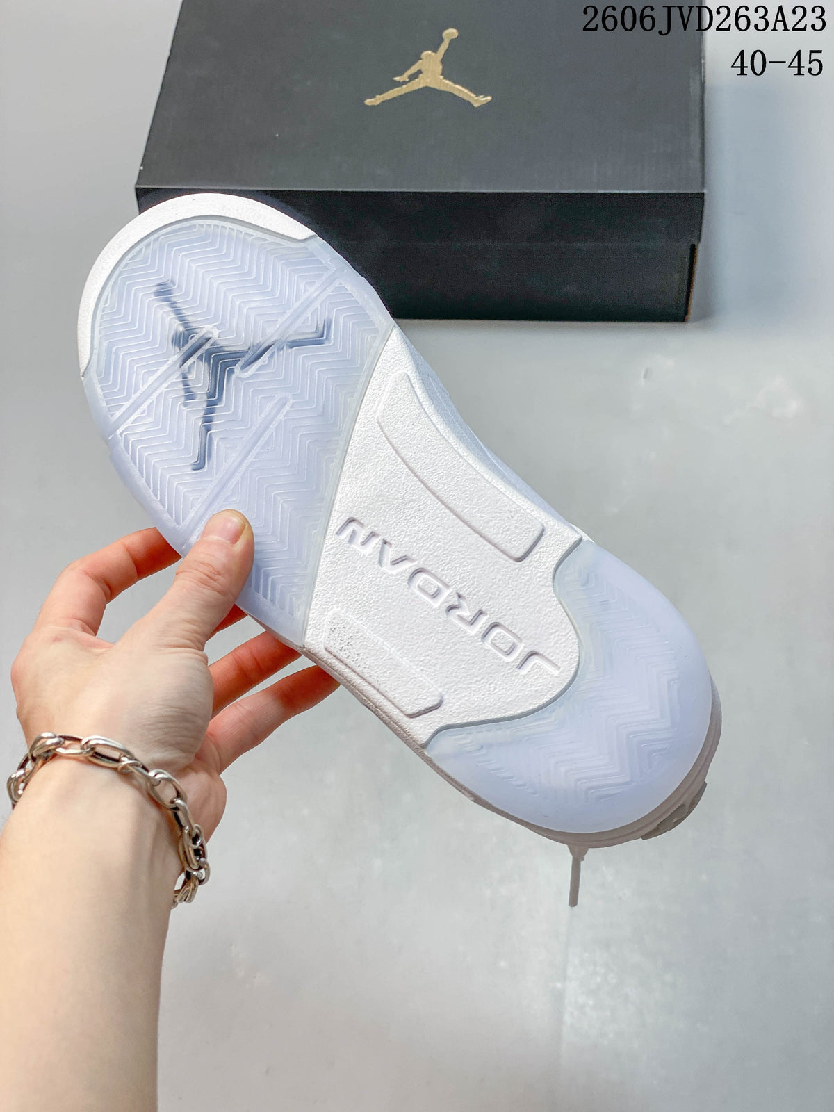 Underside of a white sneaker showing a patterned outsole