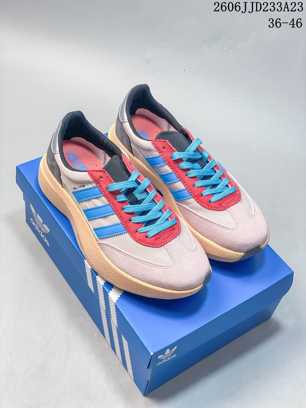 Pair of pale pink adidas Originals SL 72 Pro sneakers with blue stripes, bright blue laces, and red accents.