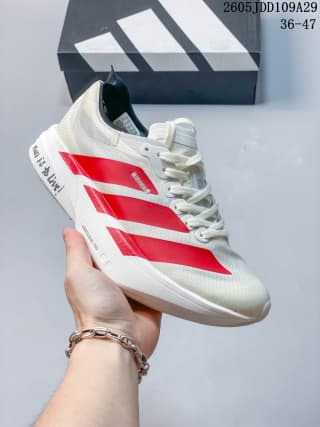 Angled side view highlighting the red stripe design, textured white upper, heel branding detail, and sculpted sole.
