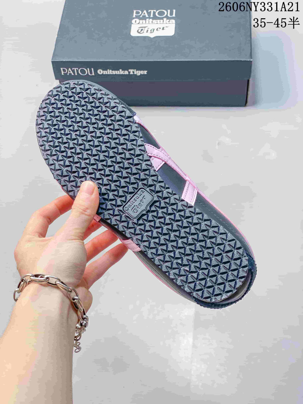 Close view of the patterned outsole and pink side detail on a navy sneaker