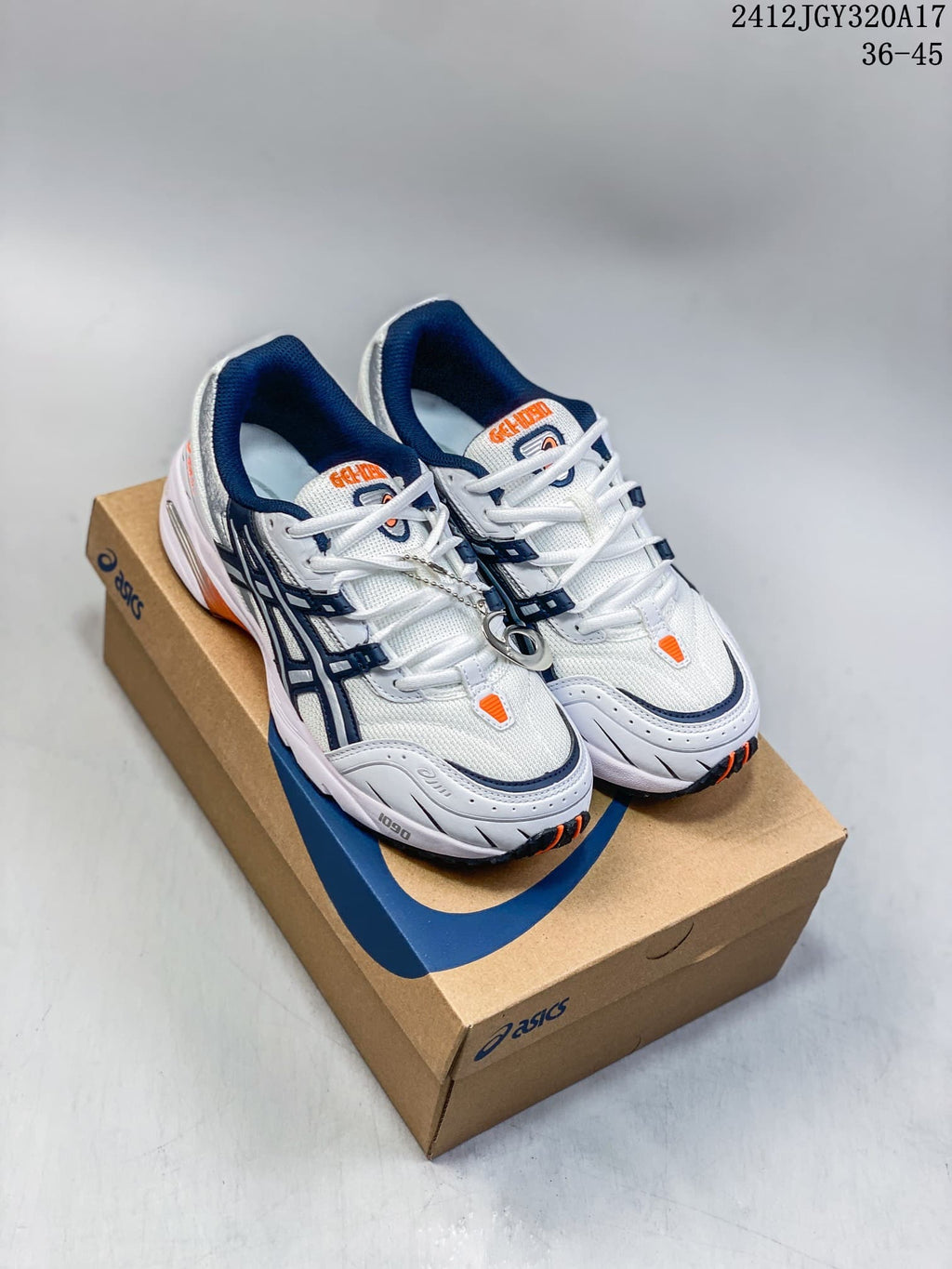 Pair of white ASICS GEL-1090 sneakers with navy and orange details on a shoebox
