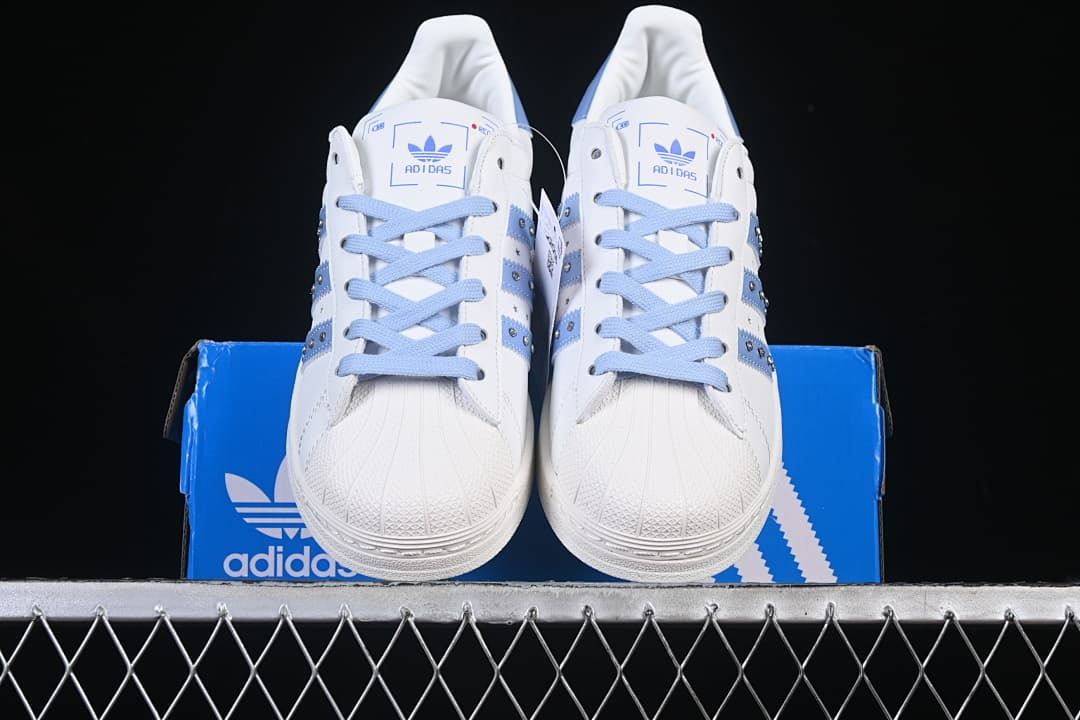 Front view of the pair showing shell toes, pale blue laces, and side details.