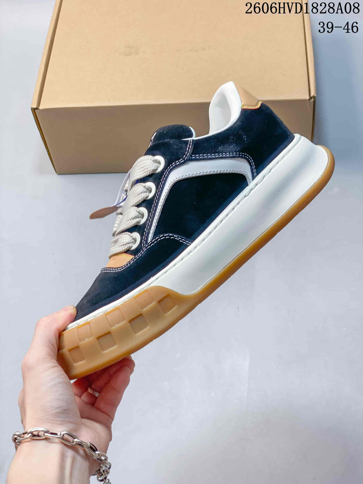 Side profile of navy low-top sneaker with white stitching and gum-colored sole
