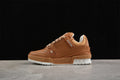 Side view of a brown low-top sneaker with tan laces and a white outsole.