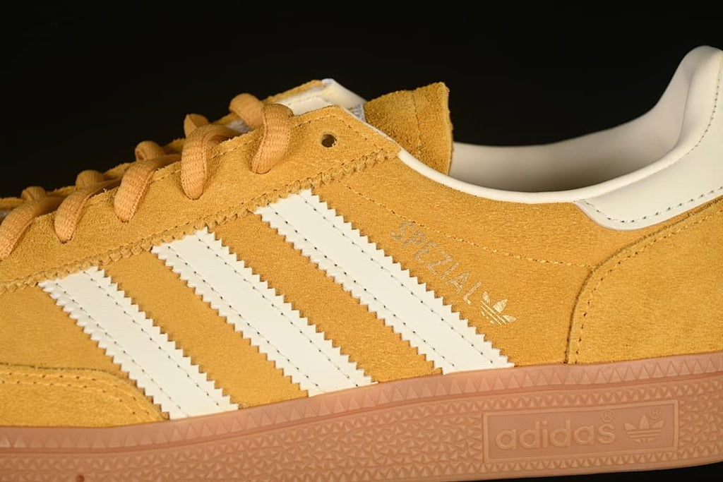 Close-up of the side stripes, yellow upper, heel panel and sole branding