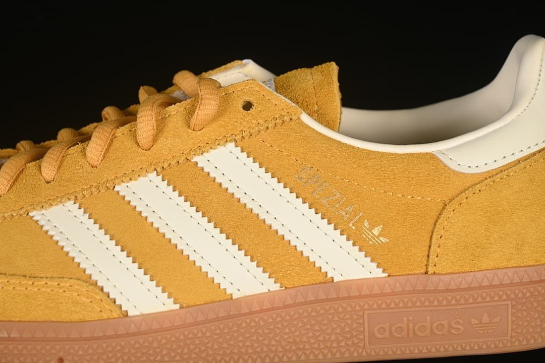 Close-up of the side stripes, yellow upper, heel panel and sole branding