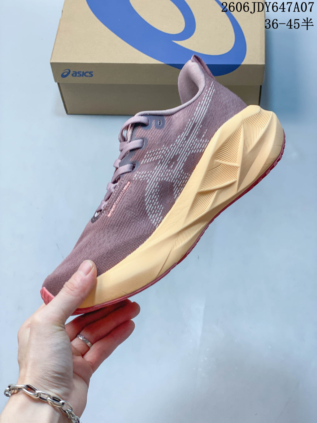 Side view of a mauve ASICS Novablast 5 running shoe with a sculpted pale yellow midsole