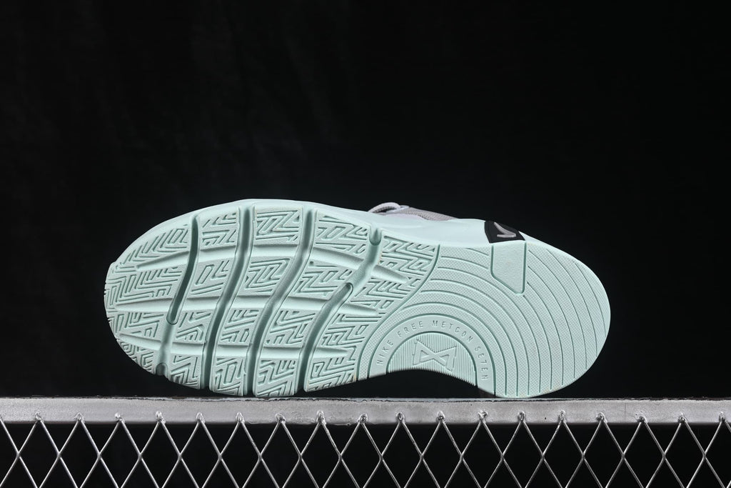 Underside view showing the pale green outsole with segmented grooves and a textured traction pattern.