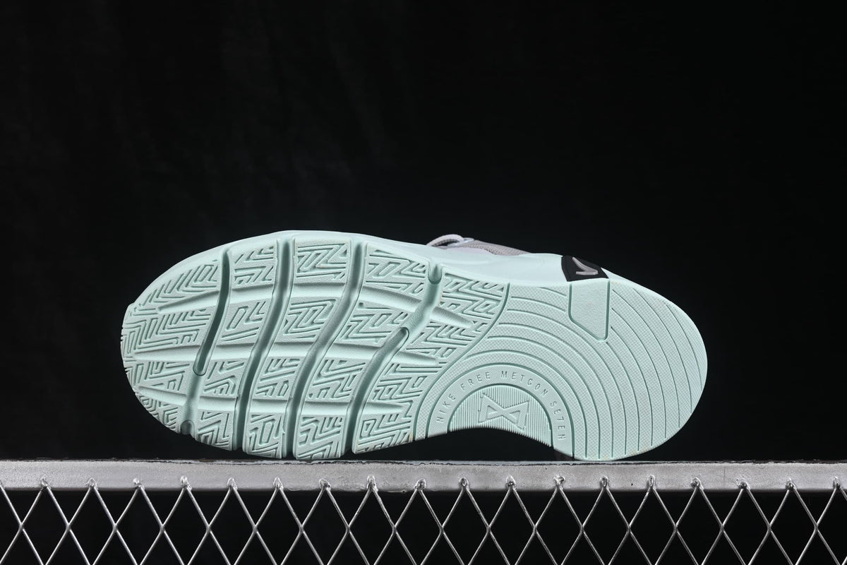 Underside view showing the pale green outsole with segmented grooves and a textured traction pattern.