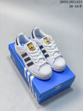 Pair of white Adidas Superstar sneakers with dark stripes and shell toes, displayed on a blue shoe box.