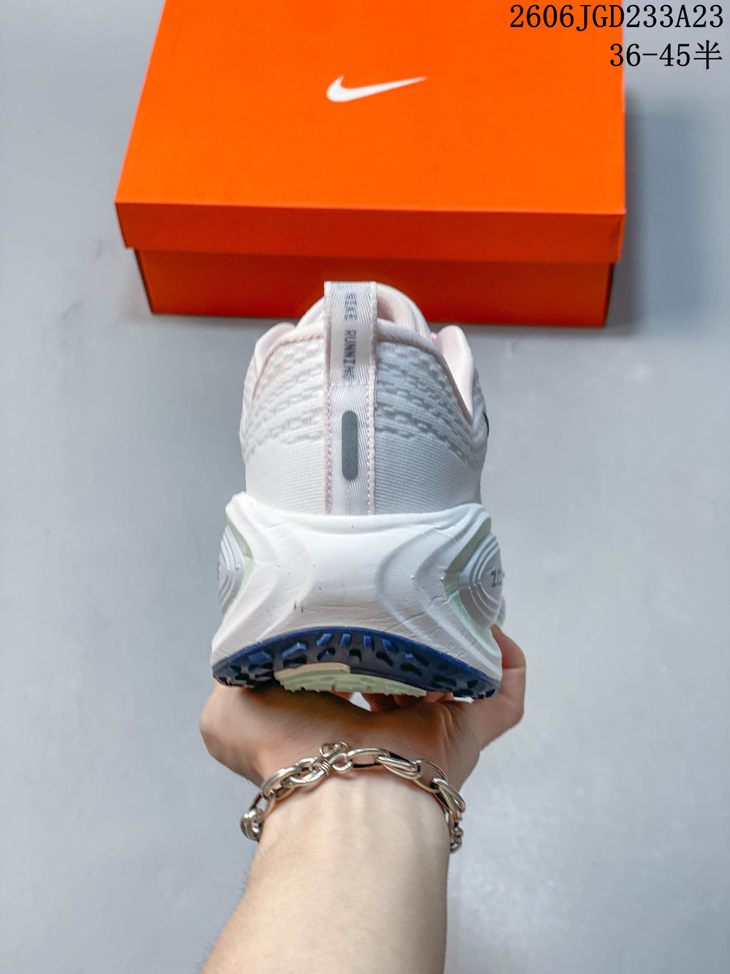 Rear view showing the heel and sculpted midsole of the white shoe.