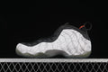 Side view of white and gray patterned Nike Air Foamposite One sneakers with black trim and orange accents.