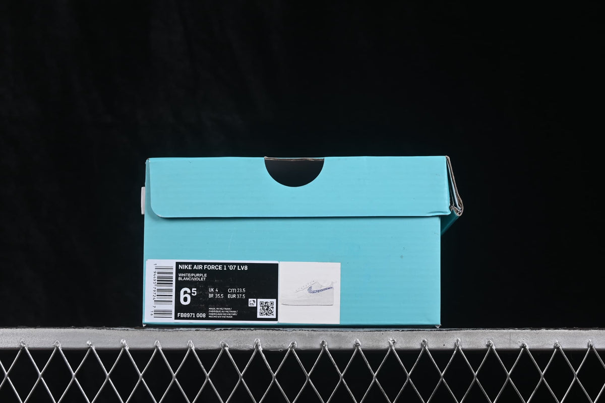 Blue shoe box with a product label showing the model, color, style code and sample size details.