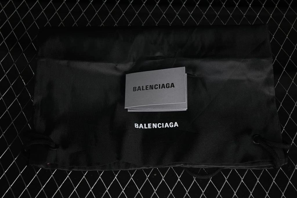 Black dust bag and branded booklet pictured with the sneaker.