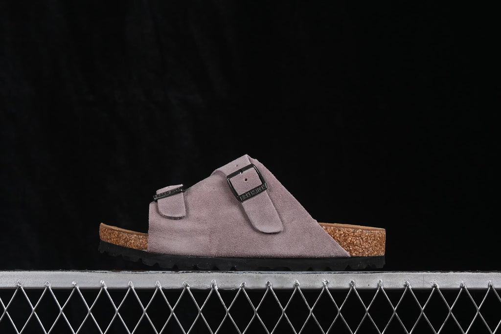 Side profile of a lavender two-strap sandal with a contoured footbed and black outsole.