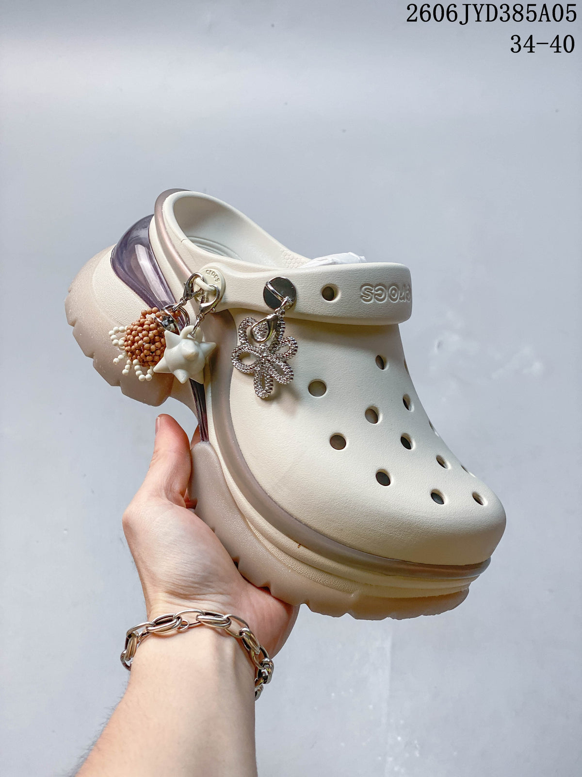 Angled view of an ivory platform clog with decorative charms
