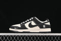 Side view of a black and off-white low-top sneaker with contrasting panels and a heel character graphic