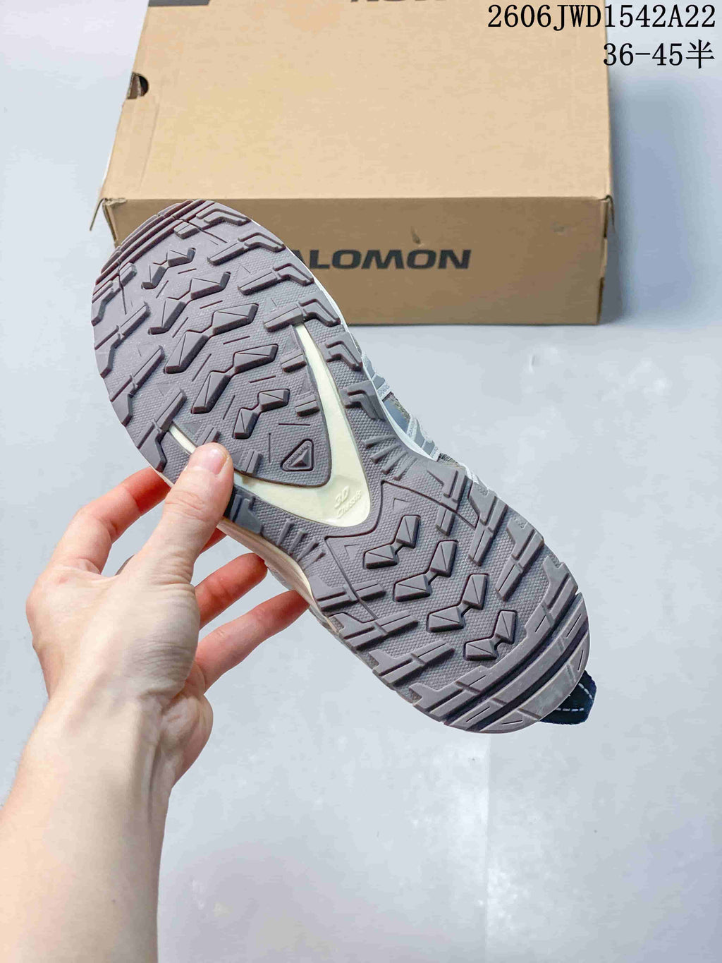 Close-up of the patterned outsole on a Salomon trail sneaker.