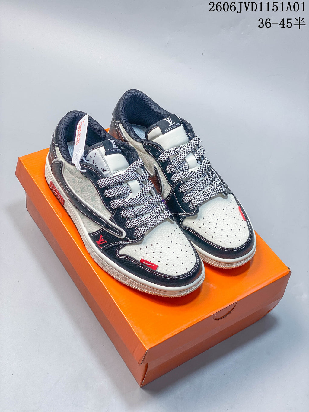 Pair of white and navy low-top sneakers shown on an orange box