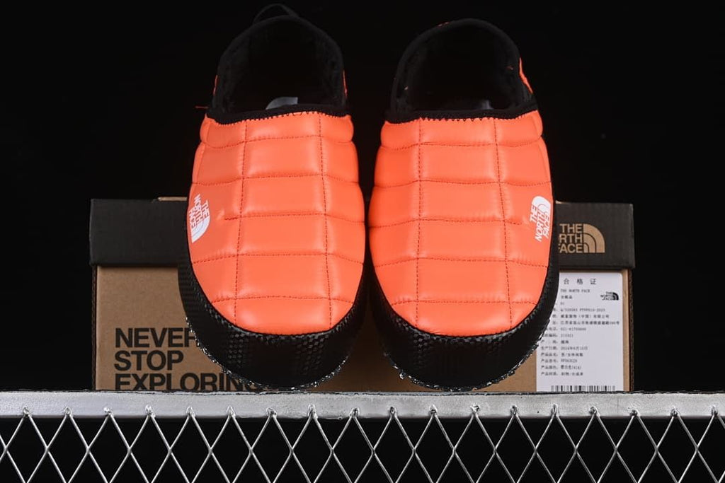 Front view of the pair of orange mules positioned on the box
