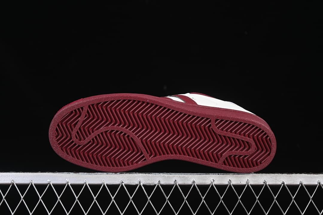 Underside view of the burgundy outsole with herringbone tread.