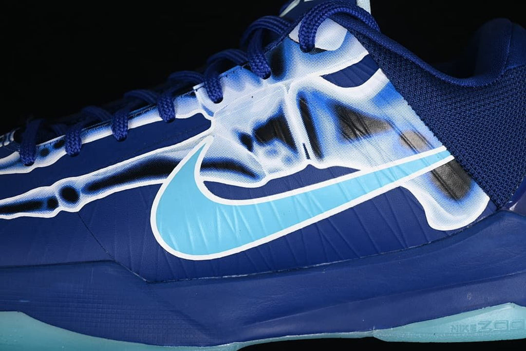 Close-up of blue upper, aqua Swoosh, and skeleton-inspired graphic