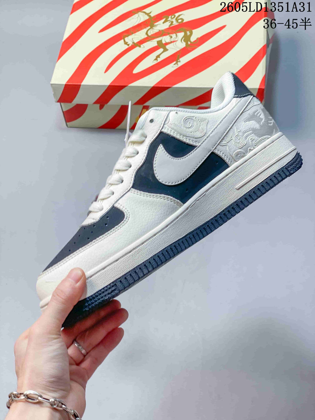 Side view of the sneaker with navy panels and embroidered upper details