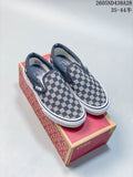 Pair of black-and-white checkerboard Vans slip-on sneakers on a branded box