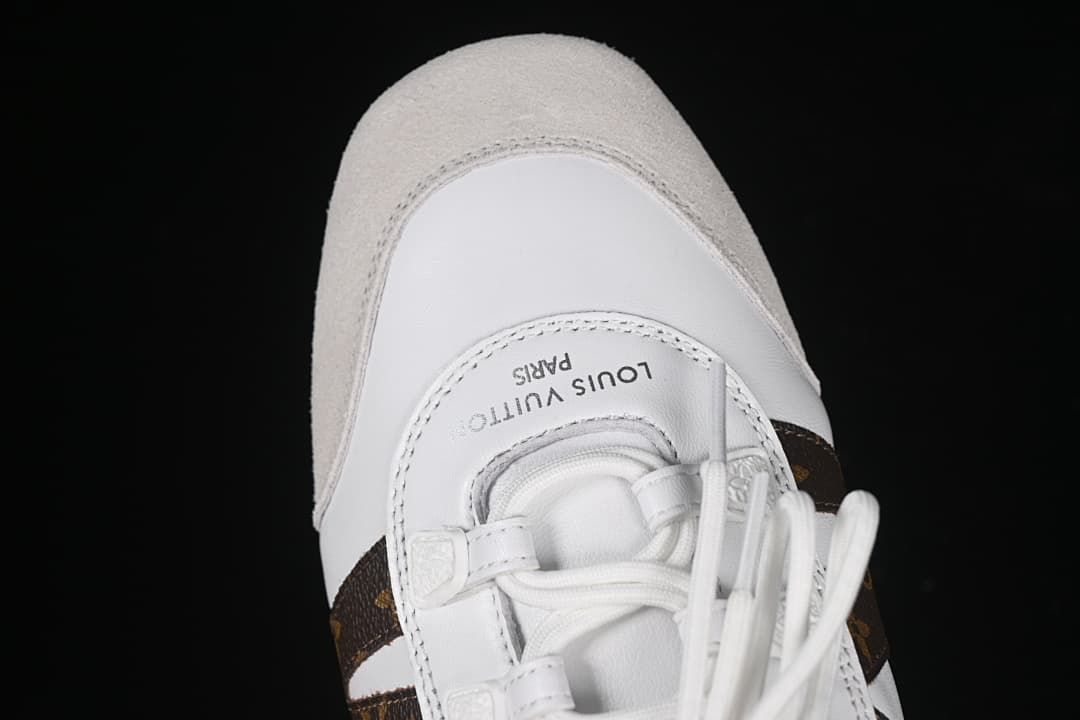 Top view of the rounded toe, light beige overlay, and lace-up front.