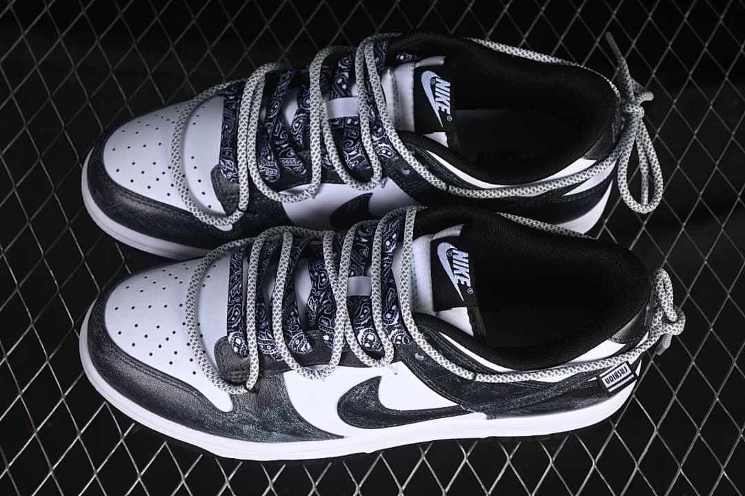 Overhead view of a pair of black-and-white low-top sneakers with patterned laces