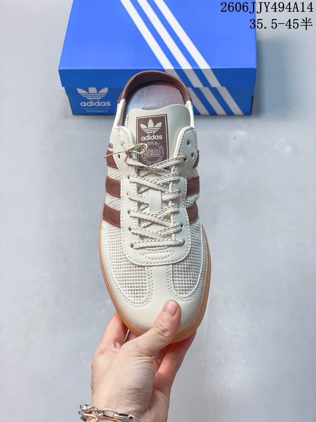 Front view of the cream-colored Samba-style mule with brown stripes.
