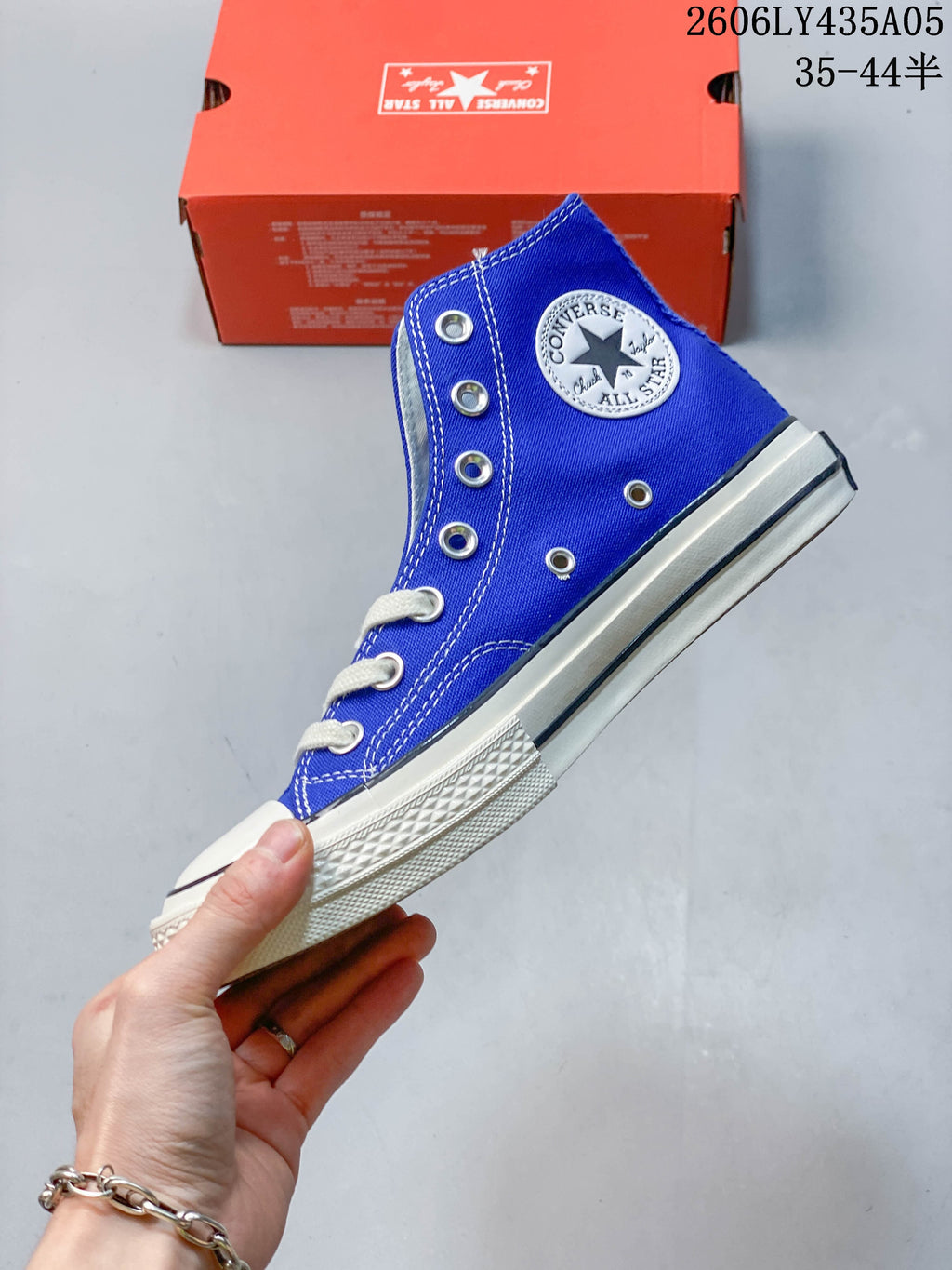 Side view of a blue high-top sneaker with a round ankle patch and white sole