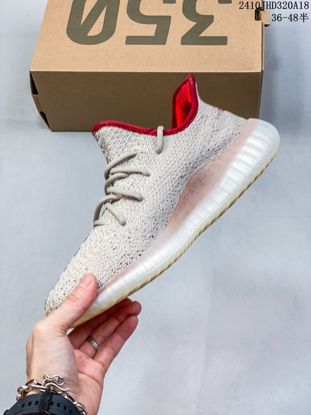 Side view of a cream knit-patterned sneaker with a red accent stripe