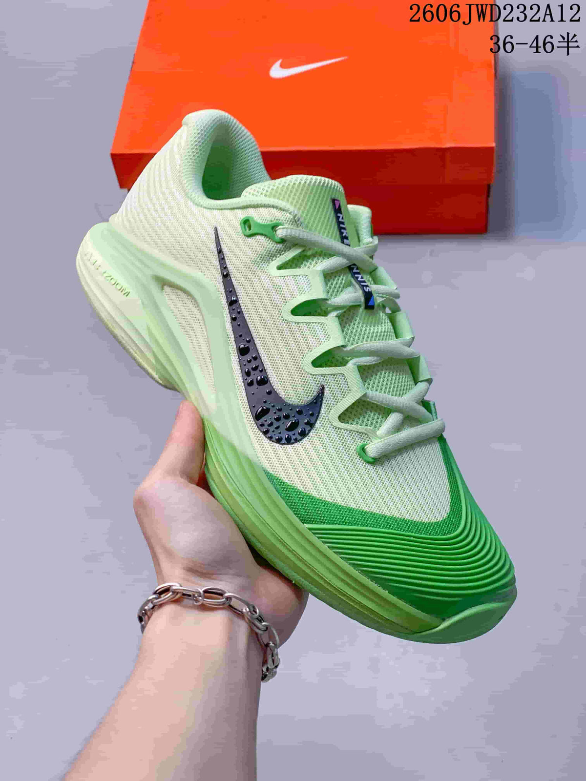 Angled view of a pale cream and green tennis shoe with a dark side logo