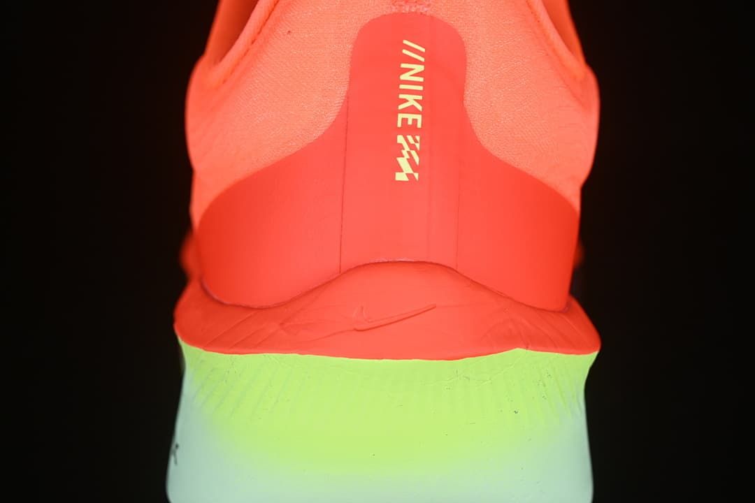 Rear view of the shoe showing coral heel and lime-to-blue-green midsole